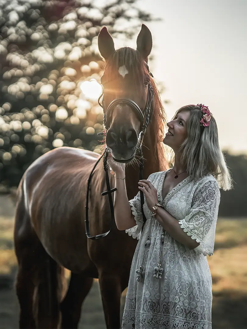 Frau mit Pferd beim Fotoshooting im sonnenuntergang