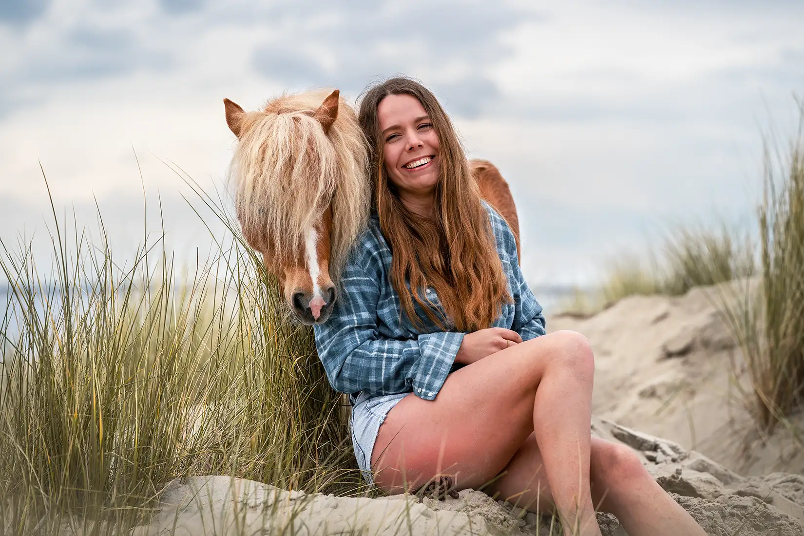 Frau posiert mit shetlandpony für ein Fotoshooting in renesse am Strand